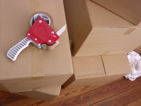 Professional movers handling household furniture and boxes in an East London property